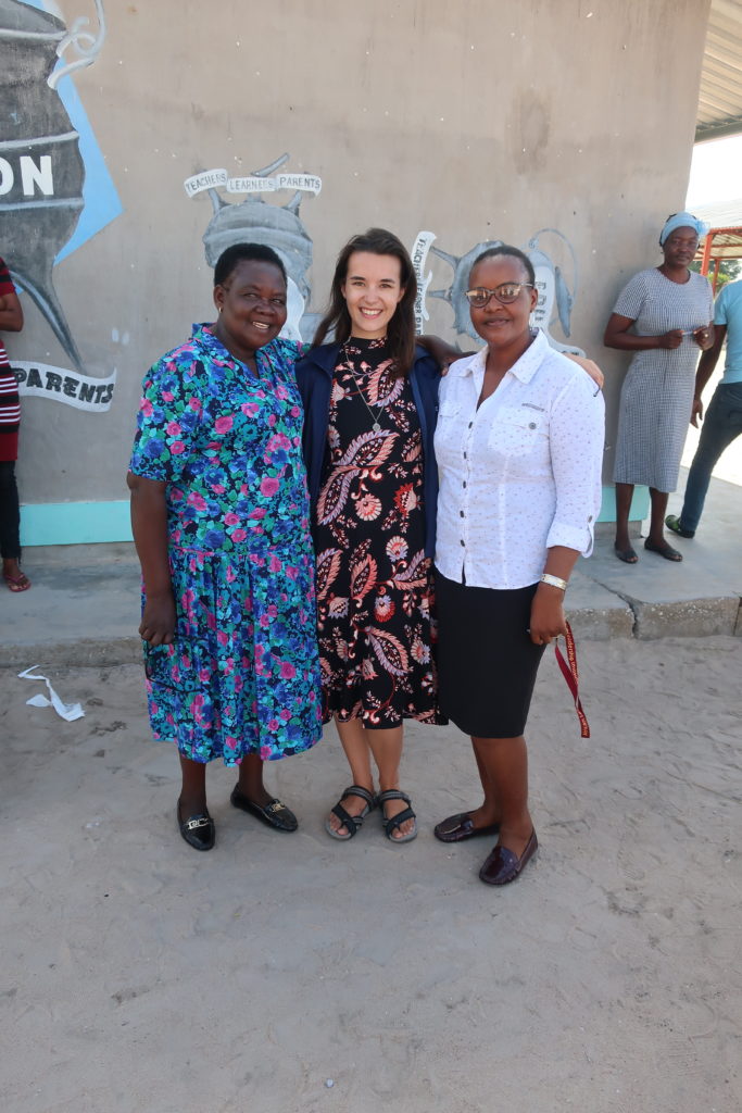 An American Peace Corps Volunteer standing with two Namibian teachers